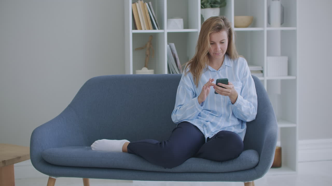 재미있는 유포리한 젊은 여성 고객이 스마트폰에서 우승 입찰을 축하하거나 전자 상거래 쇼핑 제안을 받습니다. 흥분된 소녀 우승자는 앱을 사용하여 휴대폰을보고 성공 개념을 축하합니다.