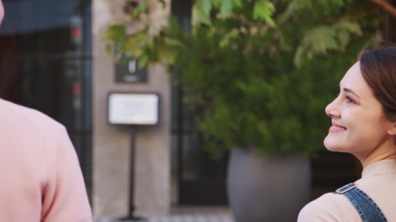 행복한 젊은 스터 커플이 도시 거리에서 손을 잡고 서로를 바라보고, 뒷면