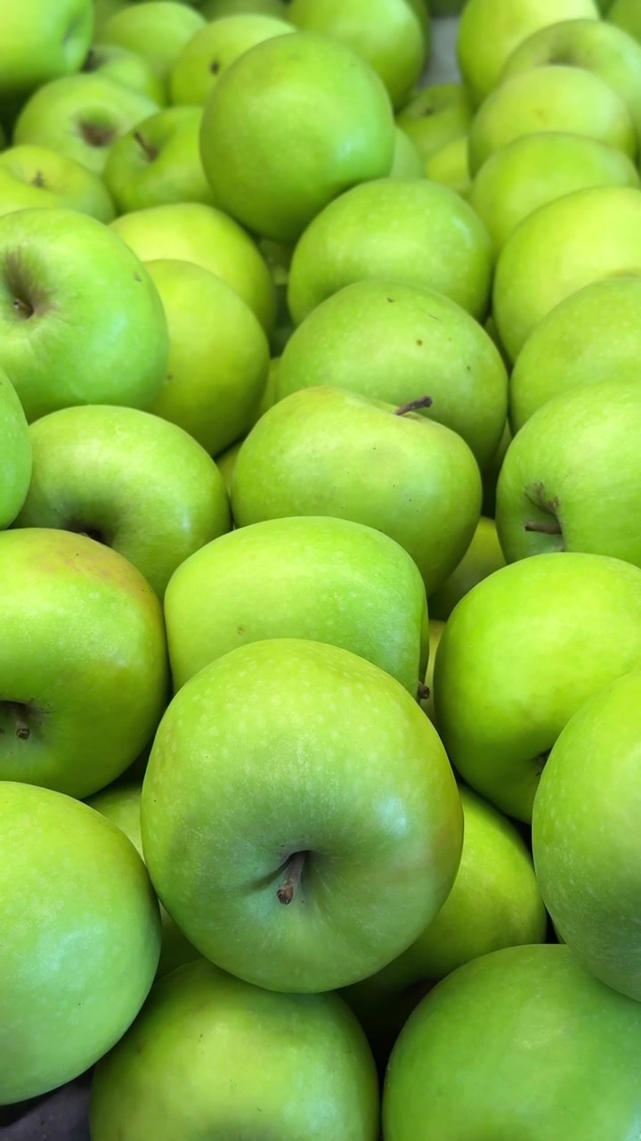 Mele verdi fresche esposte in un cesto del mercato.