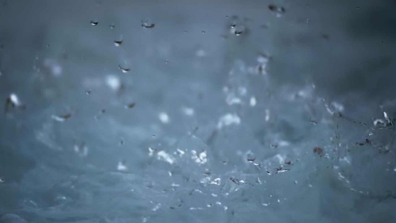 Abstrakt närbild av klart stänkande vatten med bubblor, droppar och virvlande rörelse. Blå flytande textur i makrovy med dynamisk rörelse, flytande transparens och en fräsch, ren visuell bakgrund.