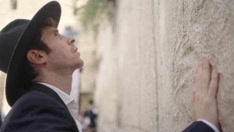 man praying at the western wall in jerusalem