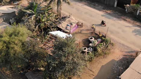 top view clip of a curious boy on bicycle watching a house construction in a rural area in battambang cambodia