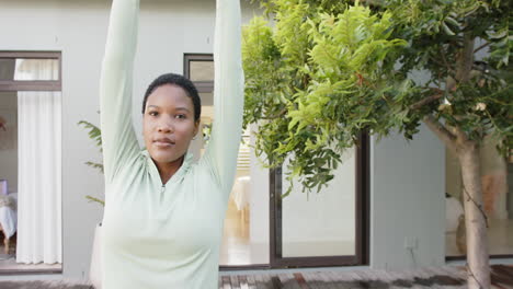 Porträt-Einer-Fokussierten-Biracial-Frau,-Die-Yoga-Praktiziert-Und-Sich-Im-Garten-Dehnt,-Zeitlupe