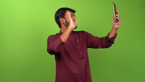 handsome man calling and talking with friends on smartphone, isolated on green screen