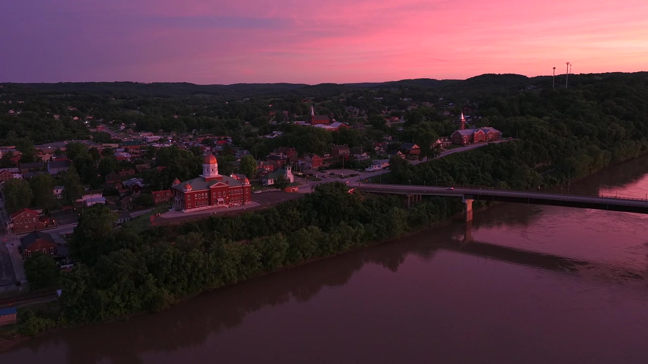 Il Tribunale della Contea di Gasconade si affaccia sul fiume Missouri, accanto al ponte Christopher S. Bond, a Hermann, Contea di Gasconade, Missouri, Stati Uniti, che risplende al tramonto, ripresa con drone in allontanamento.