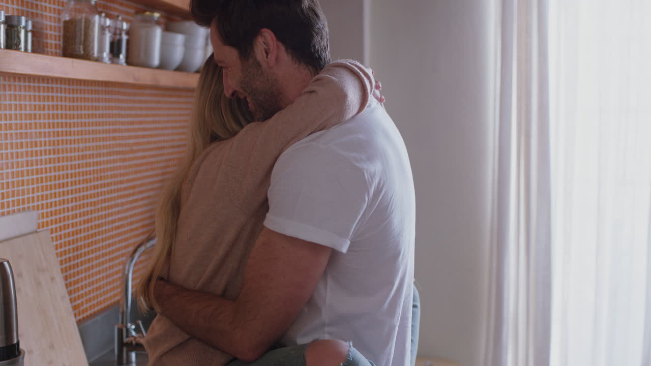 cheerful young couple hugging in kitchen having fun romantic relationship embracing sharing intimate connection enjoying happy lifestyle together