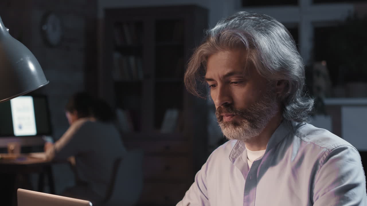 Tired Mature Man Working Late at Night in Office