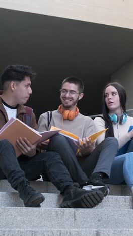 multiethnic group of students talking distracted sitting outdoors