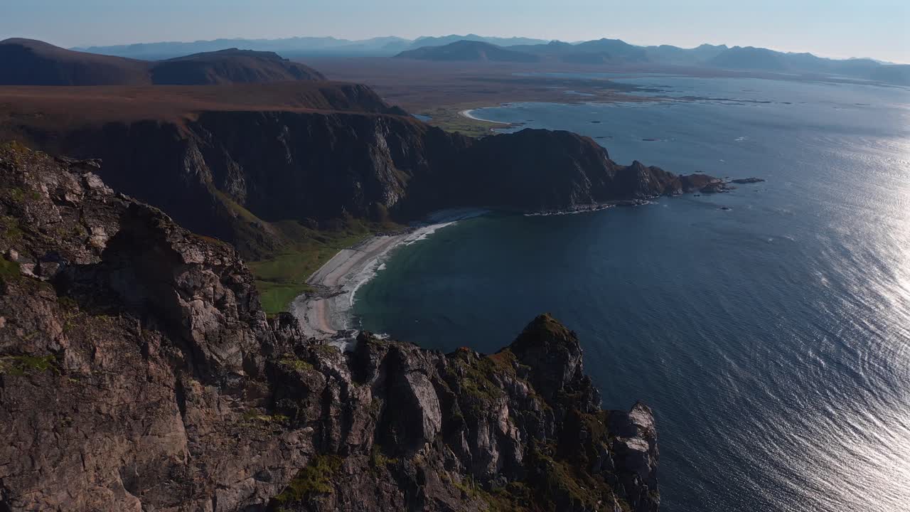 Rocky cliffs by the sea with a stunning ocean view and distant mountains at Måtinden