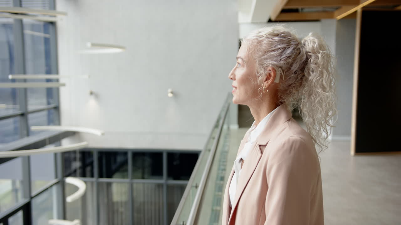 Looking out office window, businesswoman with curly hair contemplating future projects, copy space