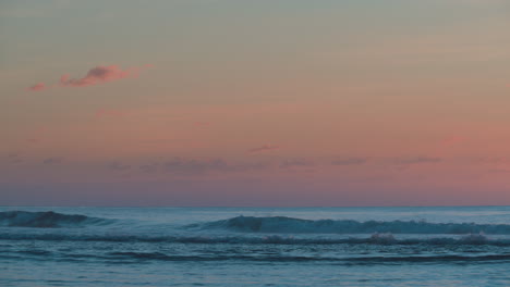 Ein-Wolkiger,-Orangefarbener-Sonnenuntergang-Am-Strand-Mit-Rollenden-Wellen-Und-Einem-Ruhigen-Gefühl