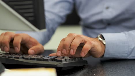 hombre de negocios escribiendo en el teclado de la computadora trabajando en la oficina