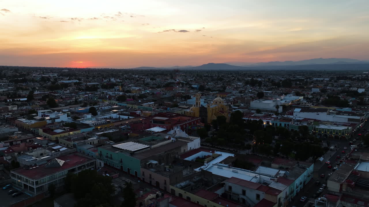 Vista aérea orbitando o centro de Huamantla, crepúsculo vibrante em Tlaxcala, México.