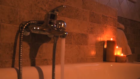 hot water filling up a home spa bathtub, for self care, with candles