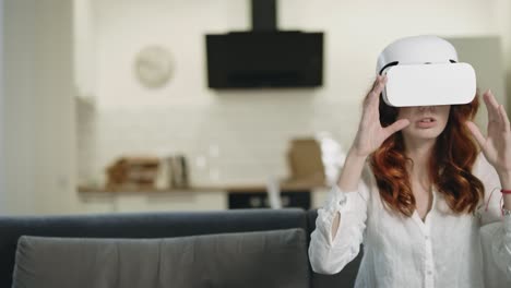 boring woman sitting on sofa in vr glasses. smiling girl playing 3d interactivity