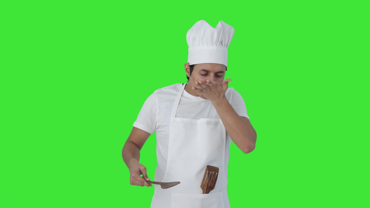 Chef professionista indiano che assaggia cibo piccante Schermo verde