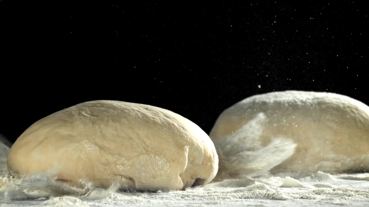 Fresh Dough Ball Dropping onto Floured Table in Slow Motion