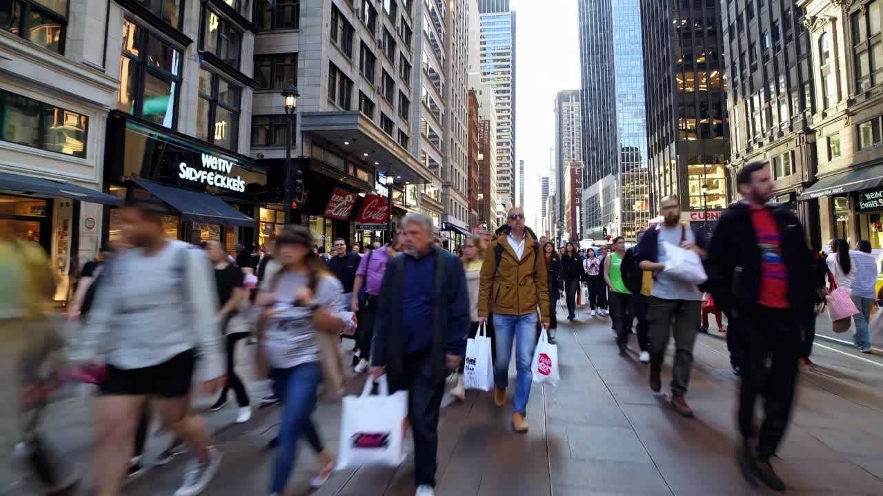 Street-level video shot of a bustling city, capturing motion blur of pedestrians