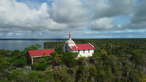 Vista-Aérea-Inclinada-Sobre-La-Capilla-De-Notre-Dame-De-Lourdes,-En-Lifou,-Nueva-Caledonia---Levantamiento,-Disparo-De-Drones