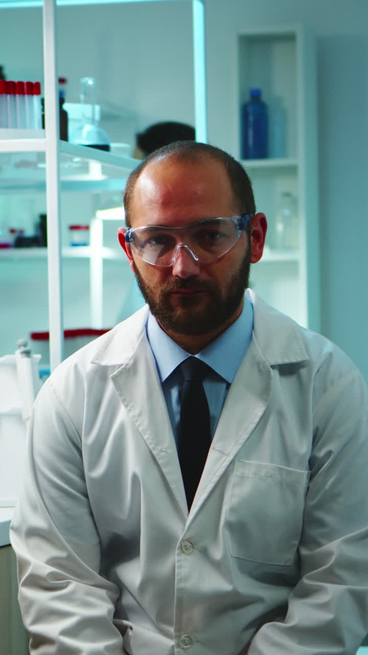 Vertical video: Tired doctor with glasses looking exhausted at camera
