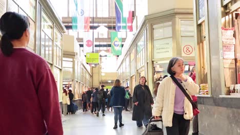 shoppers explore stalls in bustling market corridor