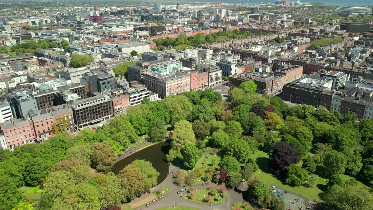 Ultra-wide advancing aerial video of St Stephen's Green and the surrounding area in Dublin City Centre, County Leinster, Ireland, on a bright and sunny day. Produced in 4K, 60FPS with Rec709 color.