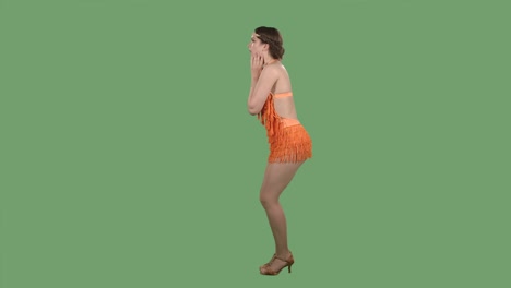 vista lateral de una hermosa mujer joven con una expresión de asombro y sorpresa en su rostro. retrato de una chica encantadora en un vestido naranja con un borde en una pantalla verde en el estudio. cámara lenta