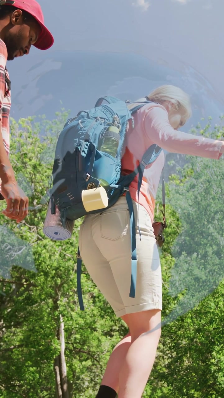 Vertical video: Woman stepping to cross hiking trail, motion lines showing pack sway, man following