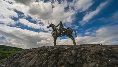 time lapse of the gaelic chieftain modern art metal statue on sunny day with moving clouds in the sky in county roscommon, ireland