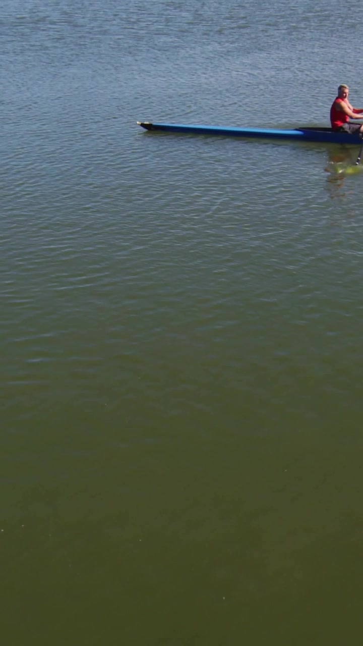 Vertical video: Male rowing on water, cursor hovering floating badges and tracking live engagement