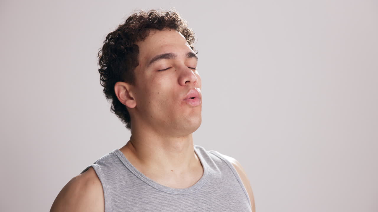 Young Man with Eyes Closed Taking Deep Breaths