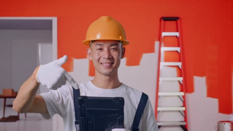 trabajador de la construcción apuntando a la tableta en una habitación bajo renovación