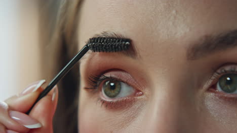 close-up of a woman applying makeup on her eyebrows