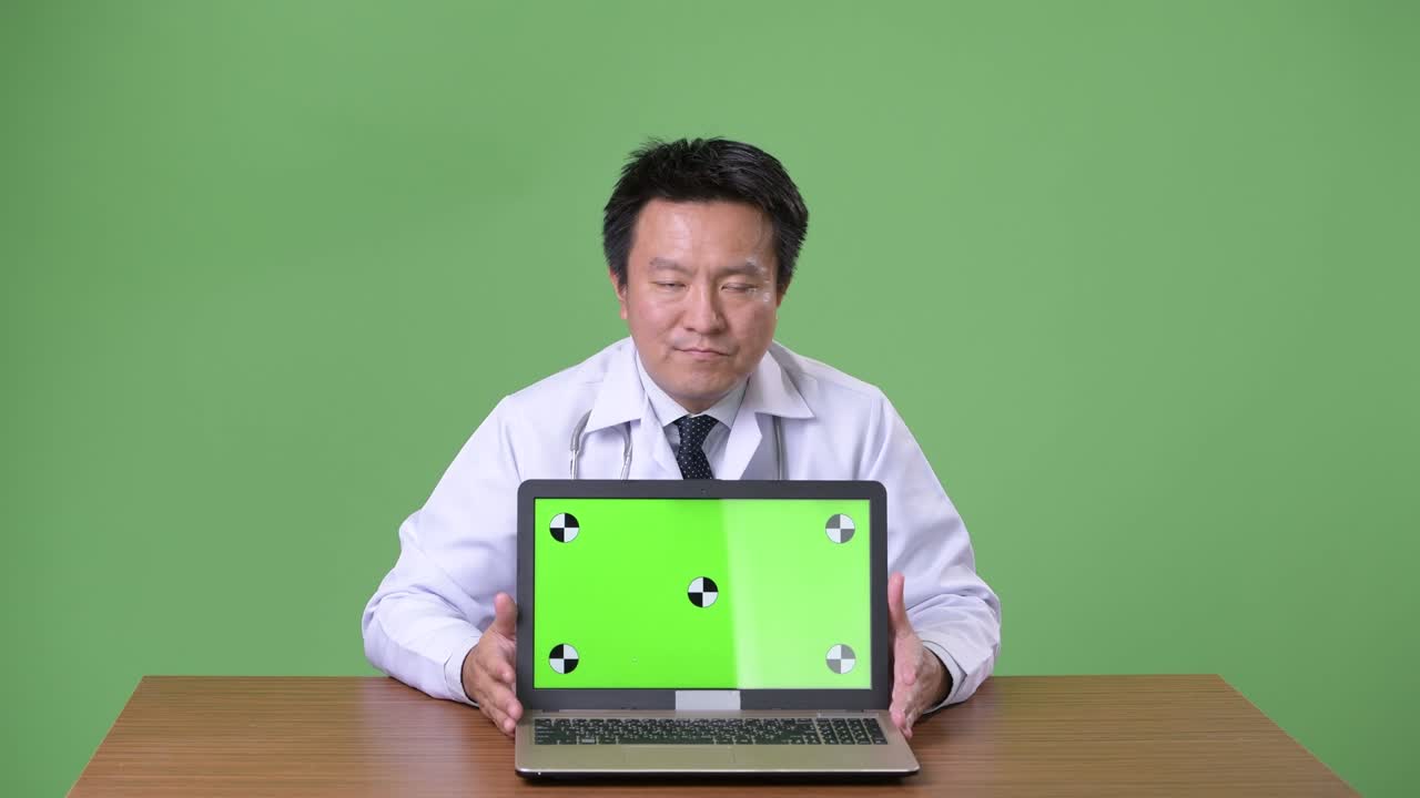 성숙한 일본인 남성, 초록색 배경의 의사