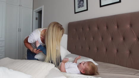 parents having fun with their little daughter on bed. family spending time at the morning