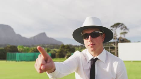 cricket umpire making signs standing on a cricket pitch