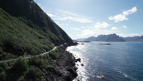 Low-aerial-forwarding-shot-of-a-famous-Norwegian-coastal-road-to-a-old-fishing-village