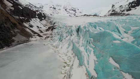 flying in snow covered glacier outlet svinafellsjökull in south iceland - aerial footage