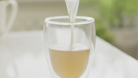 crop cook pouring broth in glass in kitchen