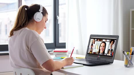 remote-job,-technology-and-people-concept--young-businesswoman-with-laptop-computer-and-papers-working-at-home-office-and-having-video-conference