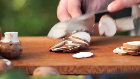 a-young-man-cuts-brown-mushrooms-on-a-wooden-board-close-up