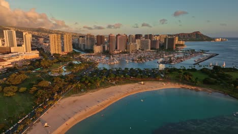 Toma-Aérea-Del-Parque-De-La-Playa-Ala-Moana,-Horizonte-De-Waikiki-Durante-La-Hora-Dorada