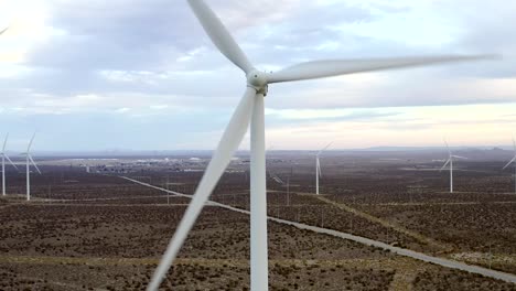 Rising-aerial-view:-wind-turbines-turning-in-large-Californian-wind-farm