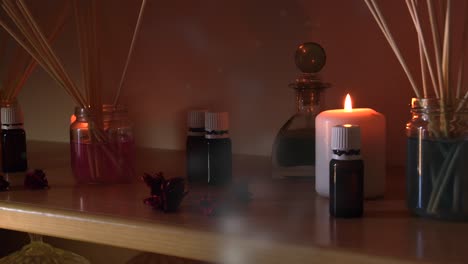 perfume making room with lots of candles flasks and glasses with colored liquids, near a steamer with steam coming out, and dust flying around