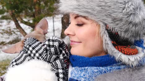 woman playing with her little dog outside winter