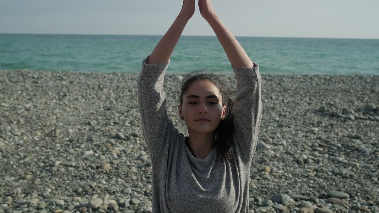 mujer practicando yoga en la playa