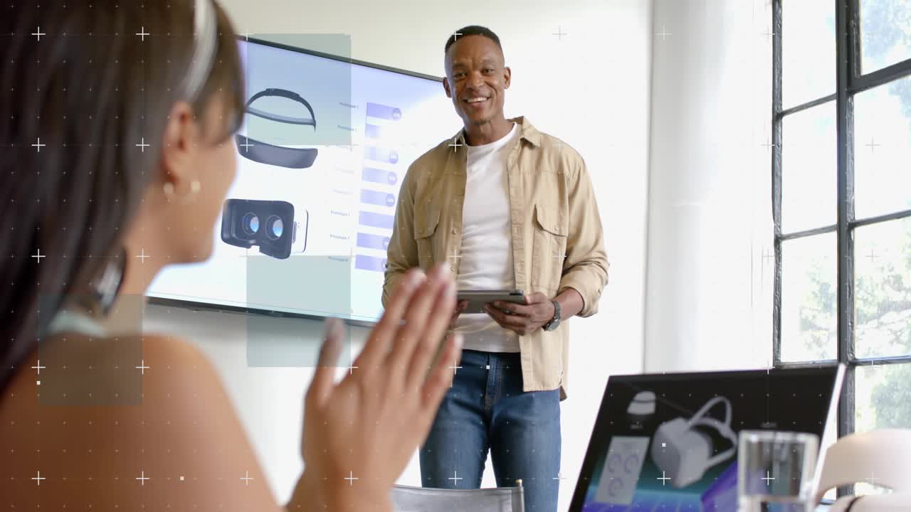 Male presenter demoing VR, pointing to sliders animating while holding tablet, attendee clapping