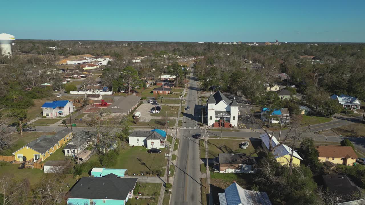 A Small Town With Colorful Houses, a Historic Church, and a Mix of Residential and Commercial Buildings - Aerial Drone Shot