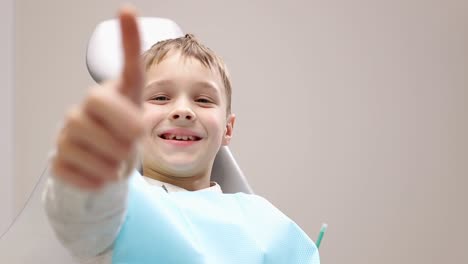 niño paciente feliz en el consultorio del dentista