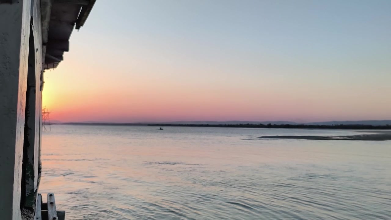 Vista serena del tramonto su un fiume calmo da una barca